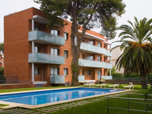 un edificio con piscina frente a un edificio en SG Costa Barcelona Apartments, en Castelldefels