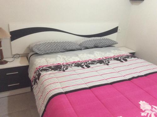 ベニドルムにあるLa Siesta Casa Jenniのベッドルーム1室(黒とピンクの掛け布団付きのベッド1台付)