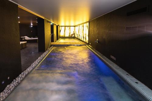 a water slide in a hotel room with blue water at Hotel Zena Beauty & Shopping Center in Hévíz