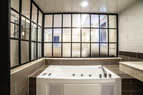 y baño con bañera y ventana. en Hotel Stay 53 en Gwangju