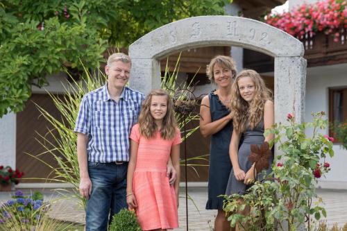 a family poses for a picture in front of a grave at Pension Zum Ebenstein am Donausteig in Untergriesbach