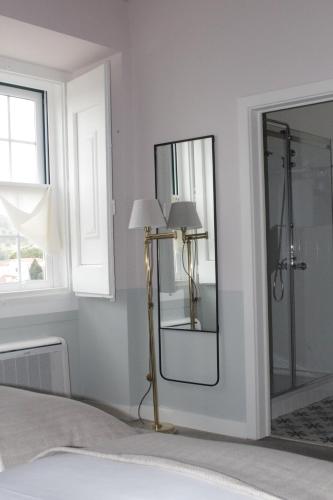 a bedroom with a mirror and a lamp at Pousada Vila Óbidos in Óbidos
