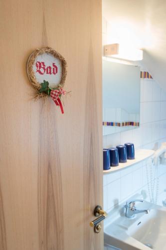 a bathroom with a door with a sign on it at Pension Zum Ebenstein am Donausteig in Untergriesbach