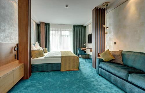 ein Hotelzimmer mit einem Bett und einem Sofa in der Unterkunft Hotel Im Engel in Warendorf