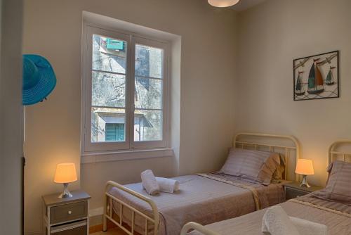 a bedroom with two beds and a window at Serene Sea View Apartment in Corfu Old Town in Corfu