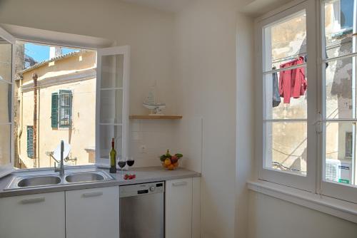 a kitchen with a sink and a window at Serene Sea View Apartment in Corfu Old Town in Corfu Town