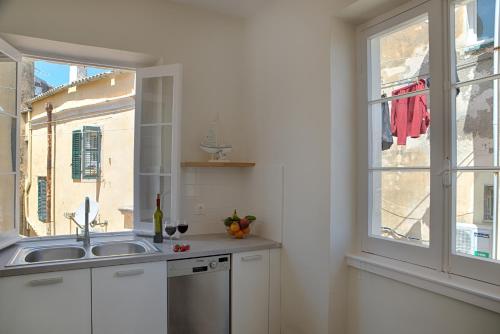 a kitchen with a sink and a window at Serene Sea View Apartment in Corfu Old Town in Corfu