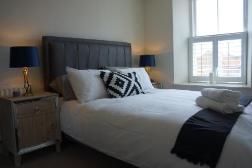 a bedroom with a large bed with white sheets and pillows at Hide Hill, Berwick Upon Tweed in Berwick-Upon-Tweed