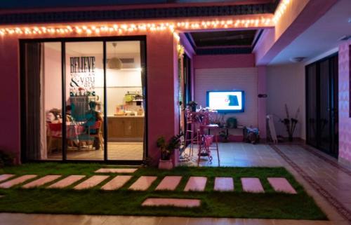 a living room with pink walls and a room with grass at Vanke Shuangyue Bay Villa in Huidong