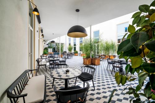 a restaurant with tables and chairs on a checkered floor at Infante Sagres - Small Luxury Hotels Of The World in Porto