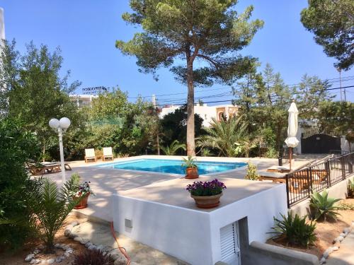 a swimming pool in a yard with trees and plants at Chalet Torralba - Villa at Hotel Osiris in San Antonio