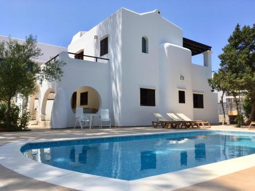 une villa avec une piscine en face d'une maison dans l'établissement Chalet Torralba - Villa at Hotel Osiris, à Sant Antoni de Portmany