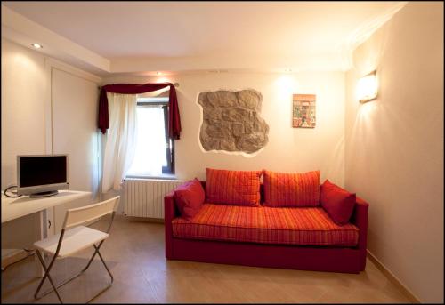 a living room with a red couch and a desk at Villa Berghinz in Venice-Lido