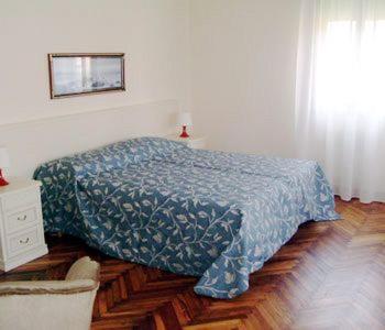 a bedroom with a bed with a blue blanket on it at Villa Berghinz in Venice-Lido