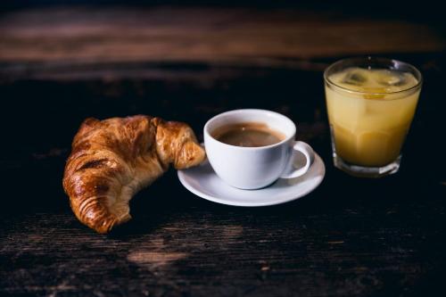 a cup of coffee and a croissant and a glass of orange juice at Generator Madrid in Madrid