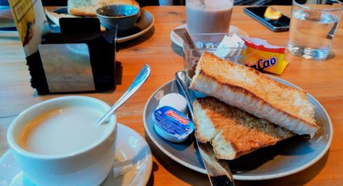 einen Teller mit einem Sandwich und einer Tasse Kaffee in der Unterkunft Pensión Garcia in Tríacastela