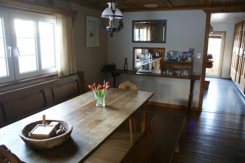 a dining room with a wooden table with flowers on it at Alpenglow Bed and Breakfast in Kimberley