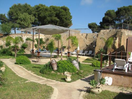 a patio with an umbrella in a yard at Residence Casale Verderame in Trapani
