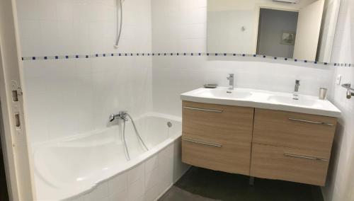 ein weißes Badezimmer mit Waschbecken und Badewanne in der Unterkunft Villas Valinco Capicciolo vue-proche mer-piscines in Olmeto