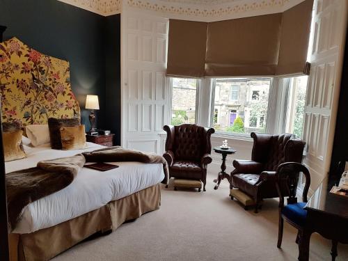 a bedroom with a bed and two chairs and a window at Barony House in Edinburgh