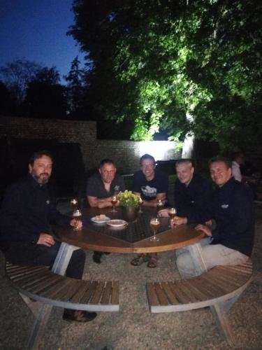 a group of men sitting around a table at night at Skindles Guesthouse in Poperinge