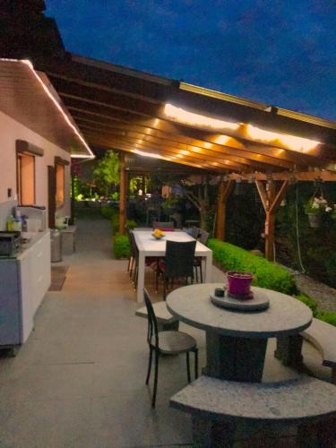 a patio with a table and chairs and a kitchen at B&B à la Madeleine in Vétroz
