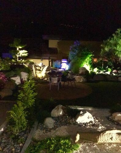 a garden at night with lights in the yard at B&B à la Madeleine in Vétroz