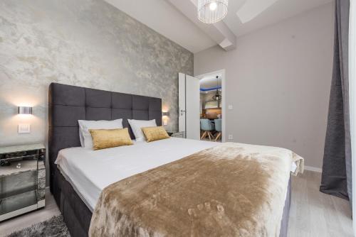 sypialnia z dużym białym łóżkiem ze złotymi poduszkami w obiekcie Luxury Apartments Marija w Sukošanie