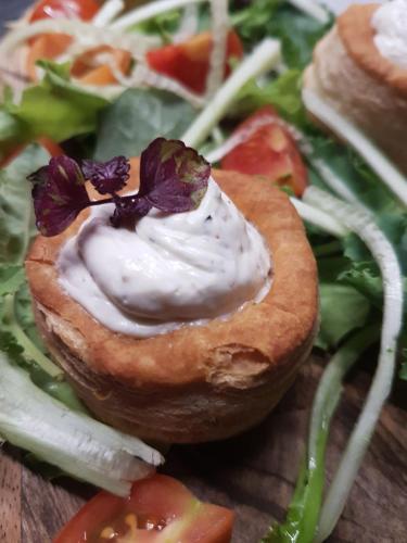 a close up of a sandwich with cream cheese and salad at Fattoria L'Olmetto in Pisa
