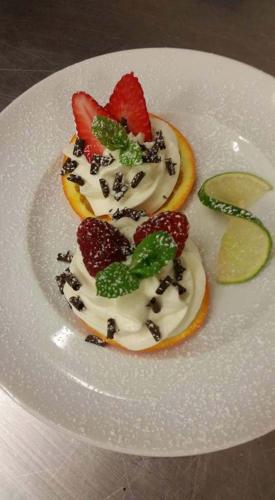 a dessert on a white plate with fruit on it at Fattoria L'Olmetto in Pisa