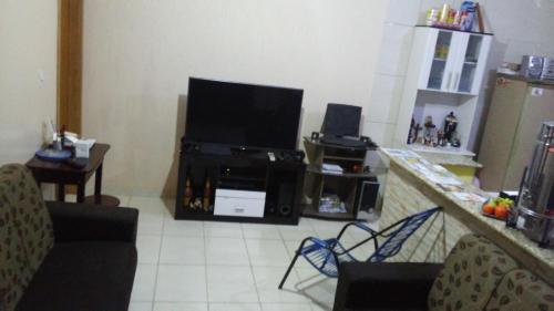 a living room with a flat screen tv on a counter at Casa e Suites in Aparecida
