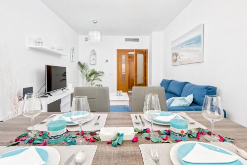 ein Wohnzimmer mit einem Tisch und einem blauen Sofa in der Unterkunft Nuevo Rincon in Rincón de la Victoria