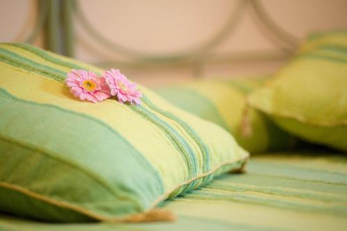 two pillows with pink flowers on them on a bed at POGGIO ECO B&B in Ascoli Piceno