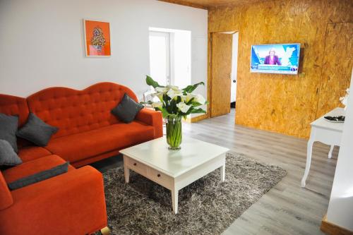 a living room with a couch and a vase of flowers on a table at Casa do Azevinho - Grupo Casas Vale do Lima in Ponte de Lima