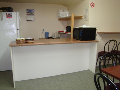 a kitchen with a counter with a microwave and a refrigerator at Hotel Quartier Latin in Montreal