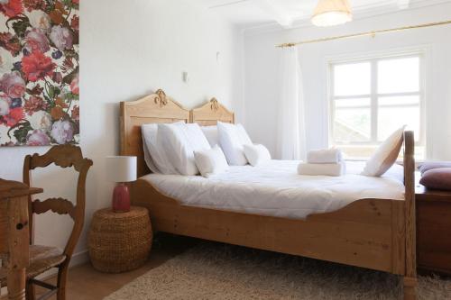 a bedroom with a bed with white sheets and a window at De Oude Pastorie Macharen in Macharen