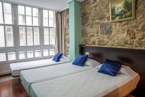 سرير أو أسرّة في غرفة في Hostal Hotil Coruña Centro