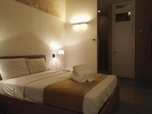 une chambre avec un lit avec deux serviettes dessus dans l'établissement Zoe 1 by Vallettastay, à La Valette