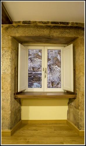 a window in a room with a stone wall at Hostal Hotil Coruña Centro in A Coruña
