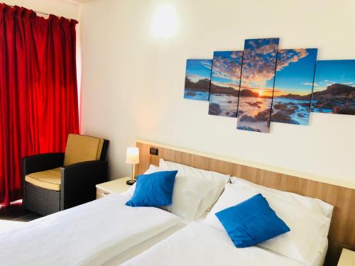 ein Schlafzimmer mit einem Bett mit blauen Kissen in der Unterkunft Residence Windsurf in Domaso