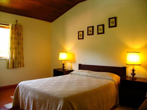 a bedroom with a bed with two lamps on it at Casa da Ponte in Alvoco da Serra