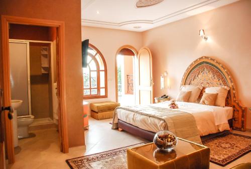 a bedroom with a large bed and a bathroom at Riad Noumidya in Fès