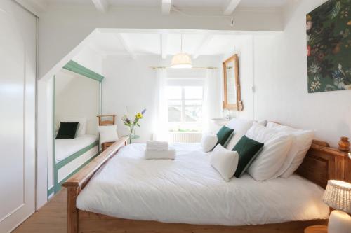 a bedroom with a large white bed with white pillows at De Oude Pastorie Macharen in Macharen