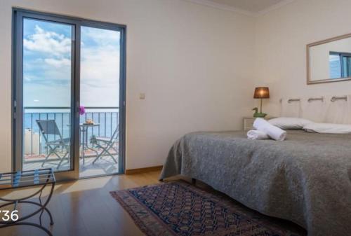 Un dormitorio con una cama y un balcón. en TRIPLEX TERRASSE VUE EXCLUSIVE SUR L OCÉAN ,WIFI, en Santa Cruz