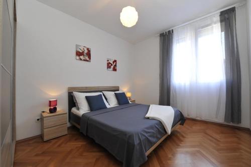 Un dormitorio con una cama grande y una ventana en Apartman Mirakul, en Split