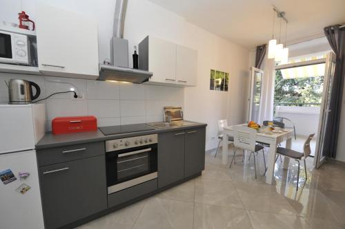 cocina con fogones, fregadero y mesa en Apartman Mirakul en Split
