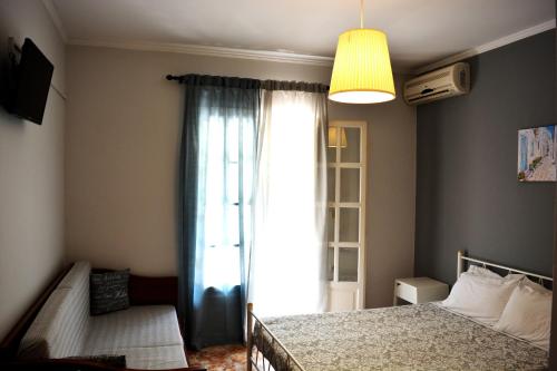 a bedroom with a bed and a large window at Apartments Despina in Sinarádes