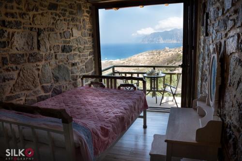a bedroom with a bed and a view of the ocean at Trahilas House in Mochlos