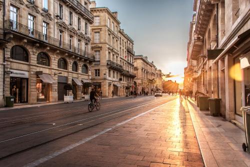a person riding a bike down a city street at Best Western Premier HBEO Bordeaux Centre in Bordeaux