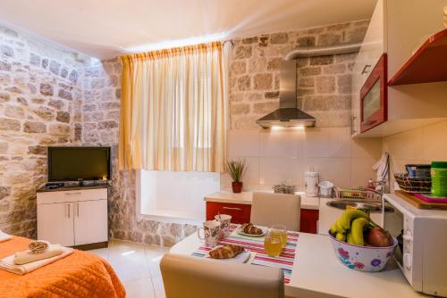 a kitchen with a table with a bowl of fruit on it at Apartments Dora -Free parking in Trogir